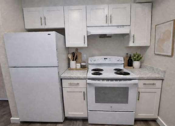 A white kitchen with a fridge, stove, and cabinets.