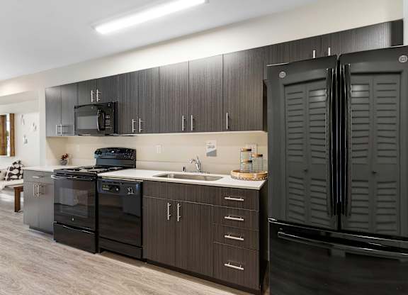a kitchen with black cabinets and a black refrigerator at Arabella Apartment Homes, Shoreline, 98155