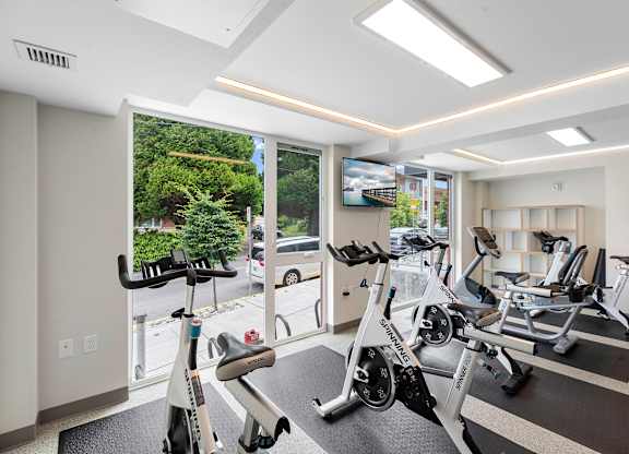 Well-Equipped Fitness Center with Exercise Equipment and Large Windows at Arabella Apartment Homes, Washington
