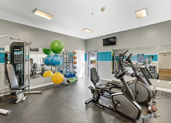 a gym with cardio equipment and weights  at Camelot Apartment Homes, Everett, WA, 98204