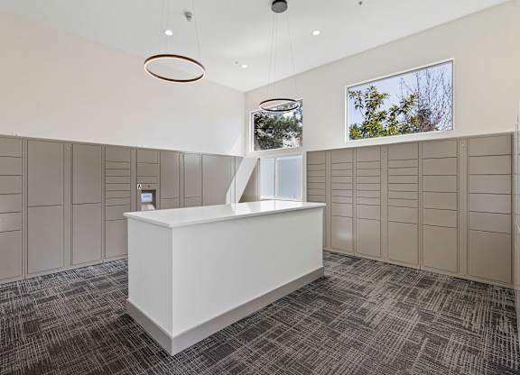 a large room with a counter in the middle and a row of lockers on the wall  at Camelot Apartment Homes, Everett, 98204