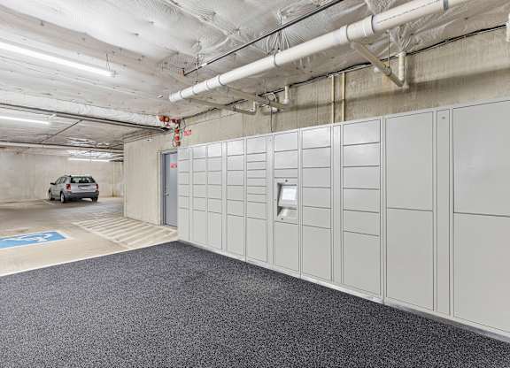 a row of package receiving lockers in the resident parking garage at Guinevere Apartment Homes, Seattle, Washington 98103