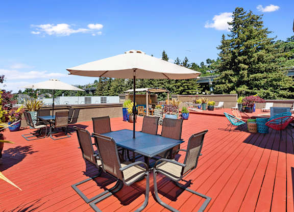 Rooftop wooden deck with tables and umbrellas at Illumina Apartment Homes, Seattle, Washington 98102