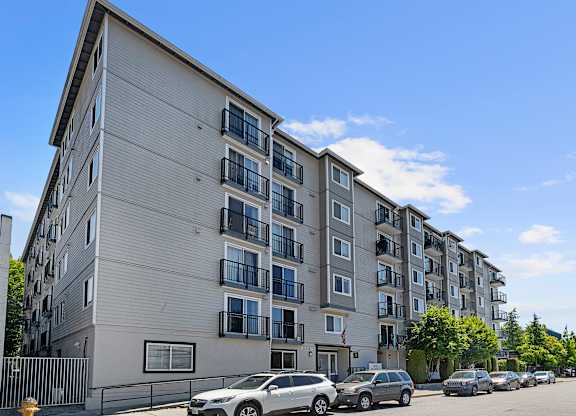 a large apartment building with cars parked in front of it at King Arthurs Court, Seattle, 98125