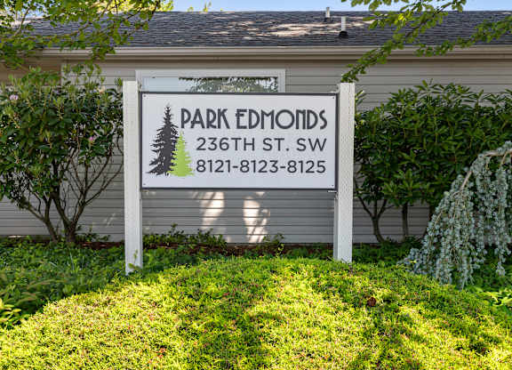 Property Sign surrounded by Green Grass and Trees at Park Edmonds Apartment Homes, Washington