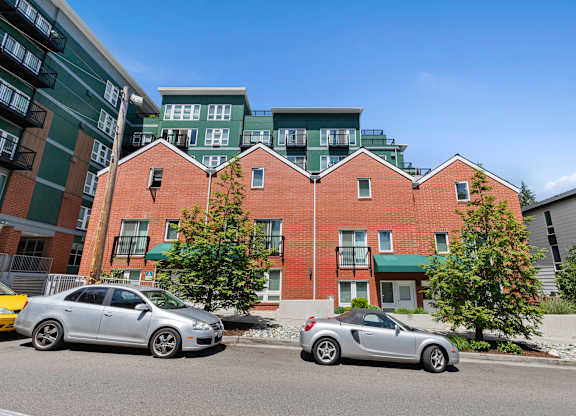a view from the street of the property building with a green awning and trees at Sedona Apartments, Washington
