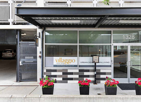 the exterior of the property with a black and white checkered tile and plants in front at Villaggio Apartment Homes, WA 98402