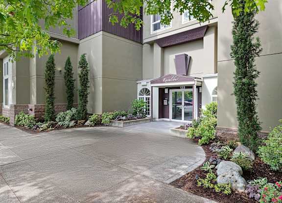 Entrance Image of Apartment Building with Decorative Landscaping to Welcome People In at Excalibur Apartment Homes, Bellevue, WA