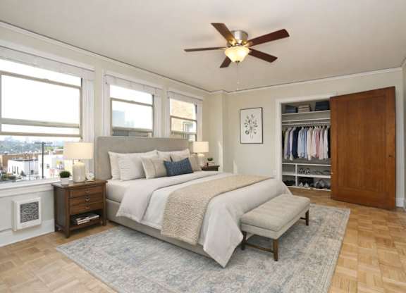 A bedroom with a large bed and a ceiling fan.