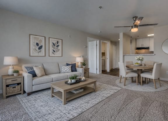A living room with a grey couch, a coffee table, and a dining table with chairs.