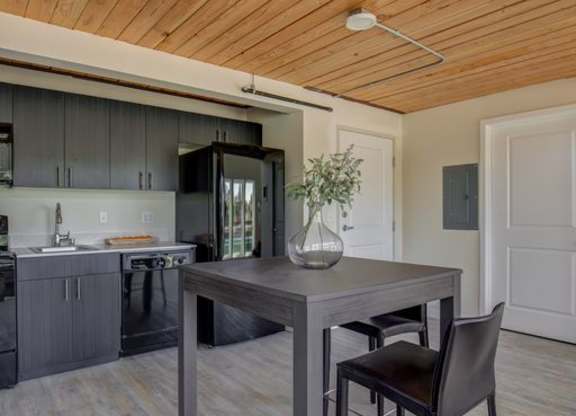 a kitchen and dining room with a wooden ceiling
