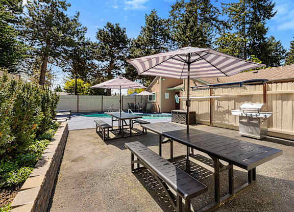 Resident Picnic Area with Picnic Tables and Striped Umbrellas at Park 210 Apartment Homes, Edmonds, WA, 98026