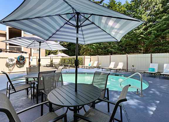 Unique Swimming Pool with Table, Chairs, and Umbrella for Relaxing in the Shade at Park 210 Apartment Homes, Washington