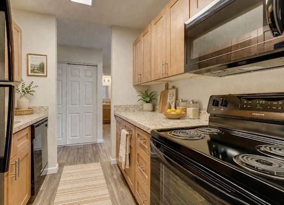 A kitchen with black appliances and wooden cabinets.