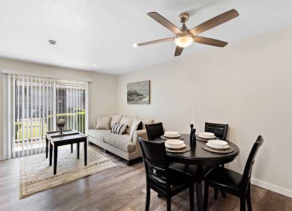 Spacious Open Space Living Room with Plank Flooring, Sliding Glass Door, and Overhead Ceiling Fan at Pinewood Square Apartment Homes, WA 98087