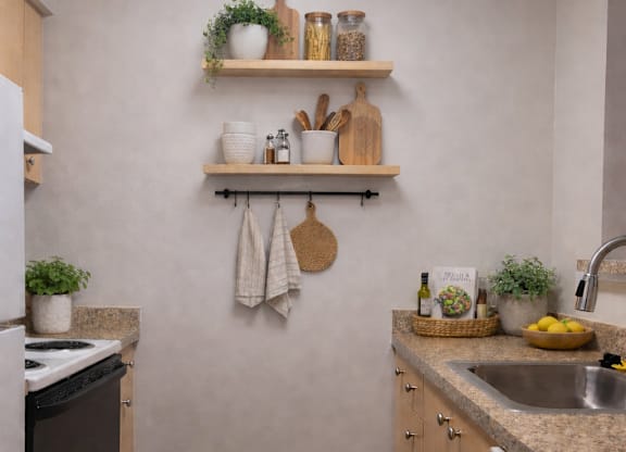 A kitchen with a white wall and wooden shelves.
