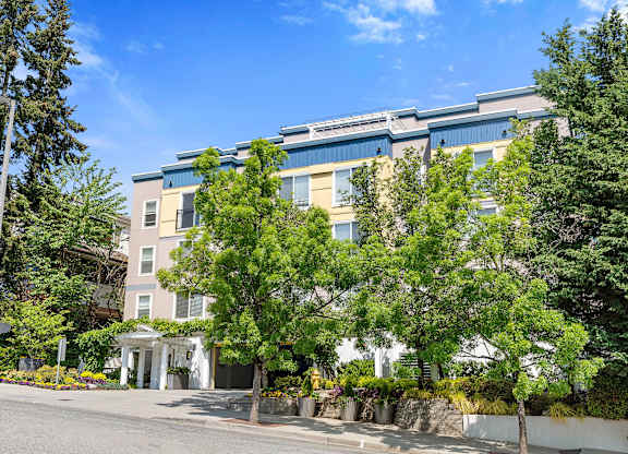 a large apartment building with trees in front of it at Sir Gallahad Apartment Homes, WA 98004