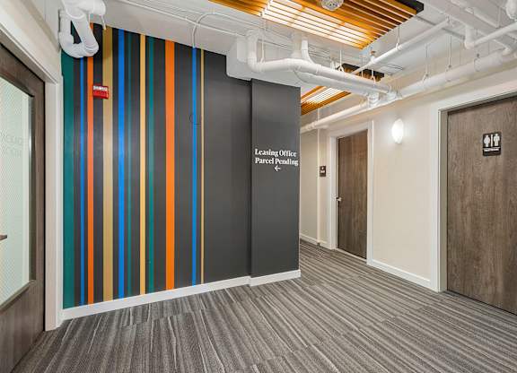 Corridor with Wall Art with a white lettering on it at Sir Gallahad Apartment Homes, Bellevue, Washington 98004