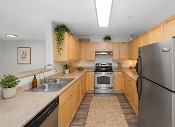 A kitchen with wooden cabinets and a black refrigerator.
