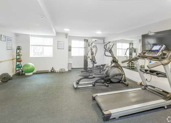 A gym with treadmills, exercise balls, and other equipment.