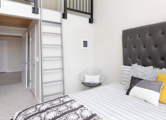a bedroom with a bed and a lofted bed