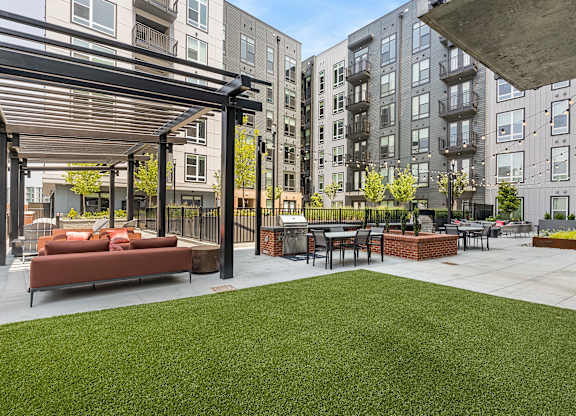 A patio area with a table and chairs is surrounded by apartment buildings.