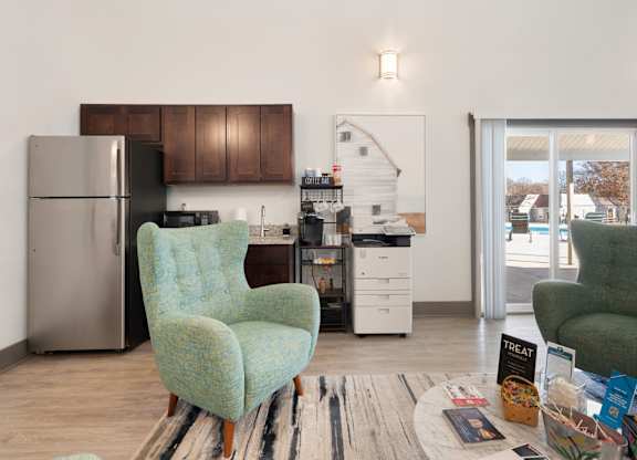 A kitchen with a refrigerator, a chair, and a dining table at Lakes Edge Apartments, Greensboro