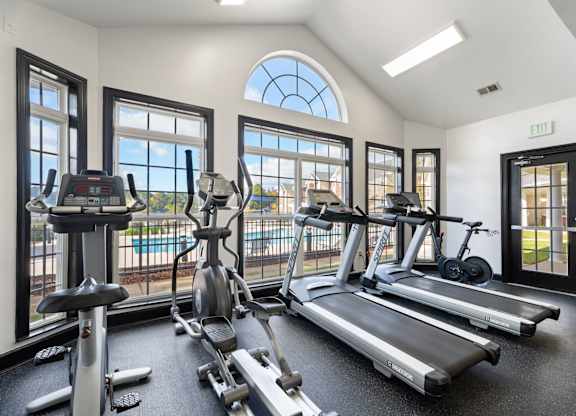 A gym with treadmills, elliptical machines, and stationary bikes. at Village on the Lake Apartments, Spring Lake, NC, 28390