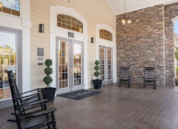A building with a stone wall and a glass door. at Stone Gate Apartments, Apartments, Spring Lake, NC