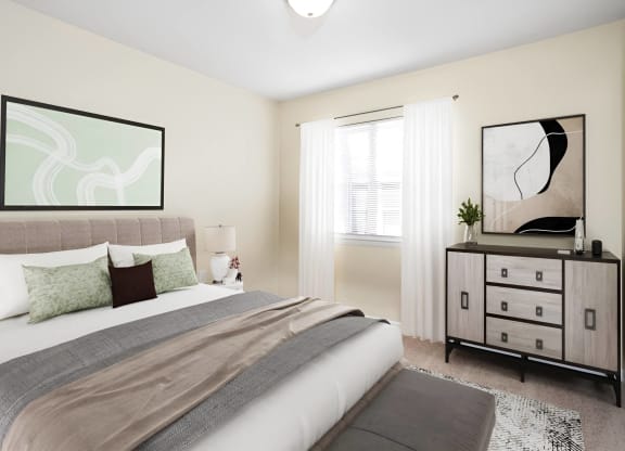 a bedroom with a bed and a dresser at West Pointe Apartments in Burlington, NC