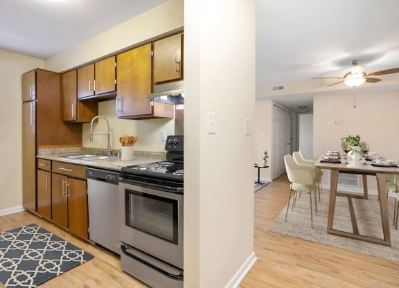 a kitchen with stainless steel appliances and a dining room table at West Pointe Apartments in Burlington, NC