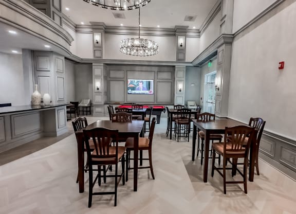 a dining room with tables and chairs and a chandelier at The Mark at Dulles Station, Herndon