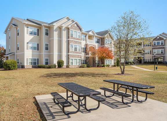 A large apartment complex with a picnic table in front. at Stone Gate Apartments, Spring Lake, 28390