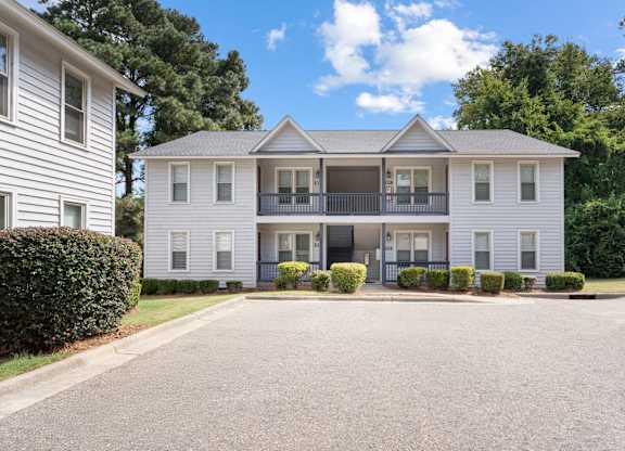 A two-story house with a balcony on the second floor. at Hunter's Ridge Apartments, Fayetteville, 28305