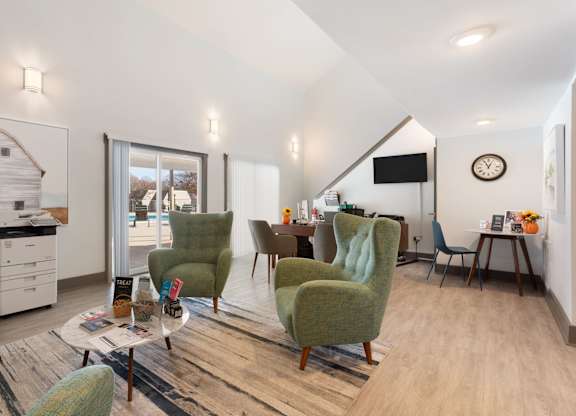 A living room with a green chair and a white sofa at Lakes Edge Apartments, Greensboro, North Carolina