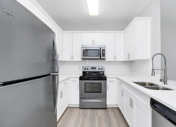 a kitchen with white cabinets and stainless steel appliances at Northlake Park, Orlando, 32827