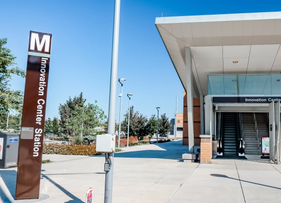 a metro station with a metro sign in front of a building at Makers Rise, Herndon, 20171  
