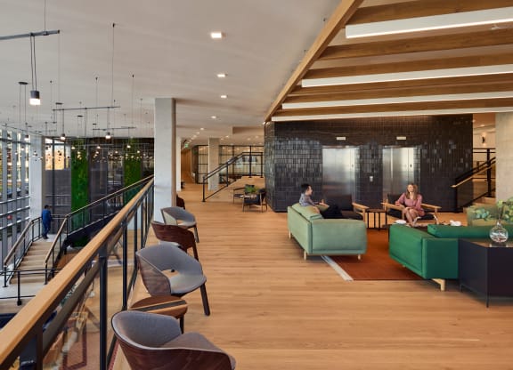 a large lobby with couches and chairs and a staircase at Makers Rise, Herndon, 20171  