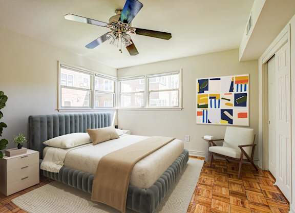 A bedroom with a bed, chair, and a ceiling fan. at Park Georgetown Apartments, Arlington, VA 22209