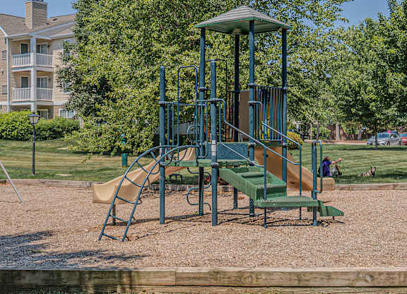 A playground with a green slide and a yellow slide.