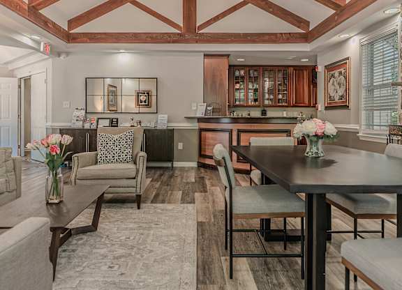 A well-lit, spacious kitchen and living room with a dining table and chairs.