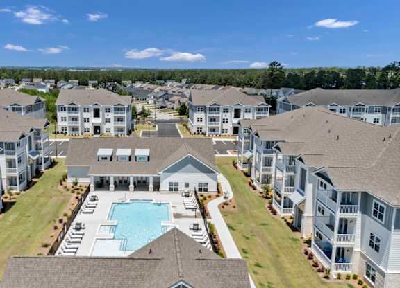 A large apartment complex with a swimming pool in the center.