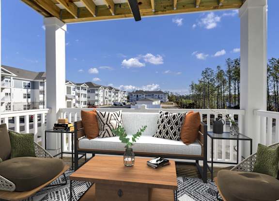 A patio with a white couch and a wooden table.