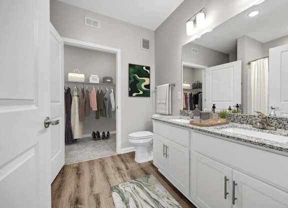 A bathroom with a toilet, sink, and a mirror.