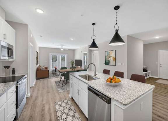 A modern kitchen with a granite countertop and stainless steel appliances.