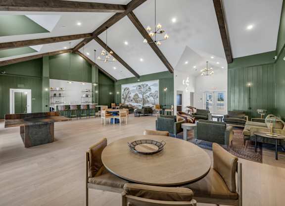 A large room with a wooden table surrounded by chairs.