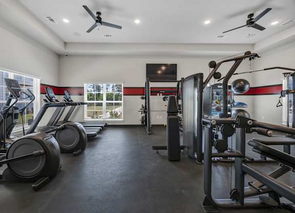 A gym with treadmills, elliptical machines, and weightlifting equipment.
