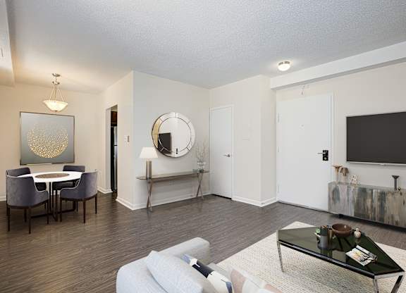 A living room with a white couch, a coffee table, and a mirror on the wall. at Columbia Uptown Apartments, Washington DC, 20009