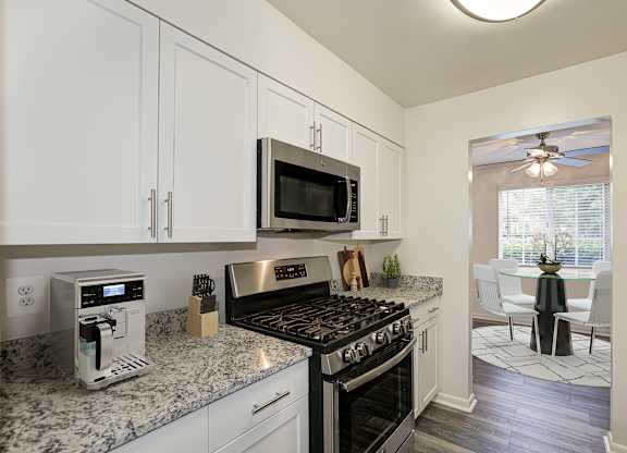 A kitchen with a black stove top oven and a microwave above it at Fairfax Square Apartments, Fairfax, Virginia