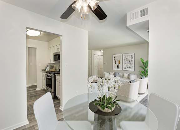 A modern dining room with a glass table and white chairs at Fairfax Square Apartments, Apartments, Fairfax, VA